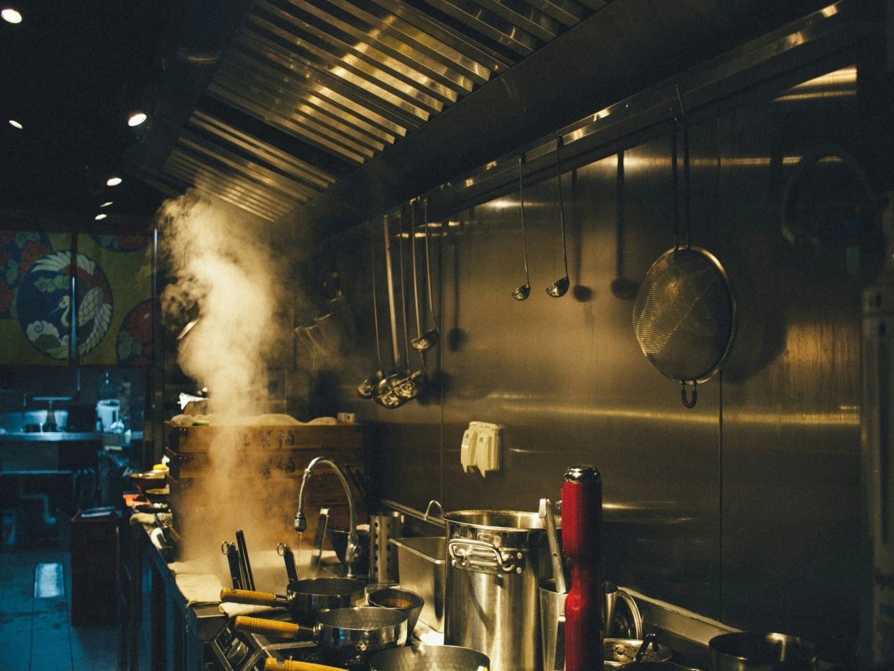 Steam rising over the line in a busy restaurant kitchen